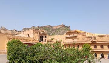 Historic amber fort with distant hills under a blue sky.