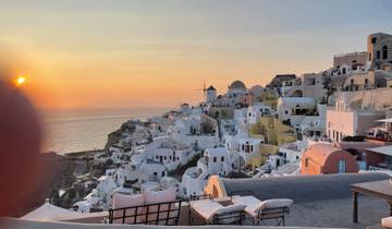 Sunset view of Santorini with white buildings and the sea.