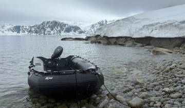 Inflatable boat docked on a rocky shore.