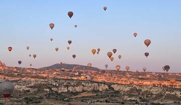 Hot air balloons over a rocky landscape.