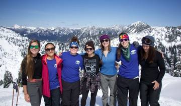 A group of friends posing in front of a snowy mountain landscape.