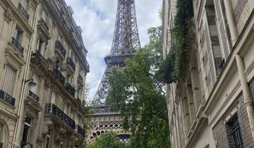 View of Eiffel Tower between Parisian buildings.