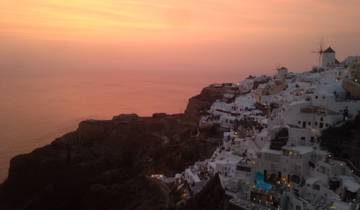 Sunset over a coastal village with white buildings.