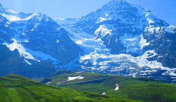 Snow-covered mountains with a clear blue sky.