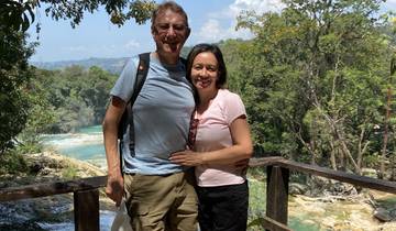 Tourist couple posing by a scenic river view.