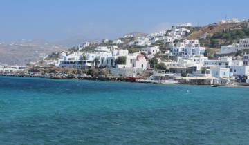 Coastal town with white buildings and blue sea.