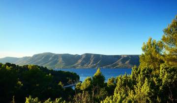 Scenic landscape with sea and green hills.