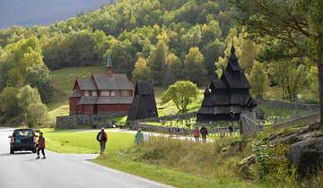 Traditional wooden church with a cemetery and tourists.