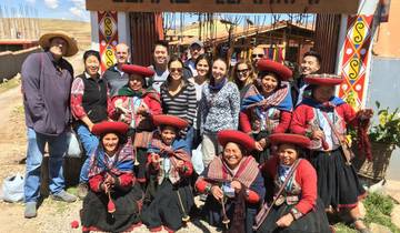 Group of people posing with locals in traditional attire.