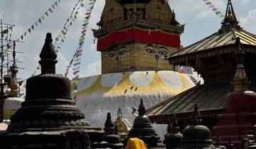 A Buddhist stupa with prayer flags against a blue sky