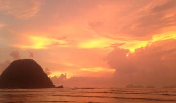 Stunning sunset over the ocean with a silhouetted rock.