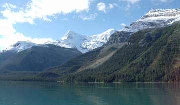 Mountain range with snow-covered peaks and a lake.