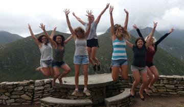 A group of women jumping in excitement on a mountainous backdrop.