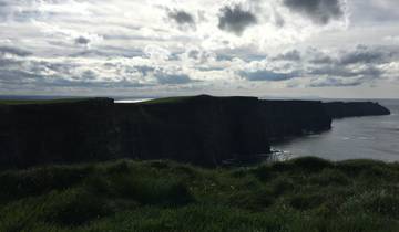 Cliffs facing the ocean under a cloudy sky.