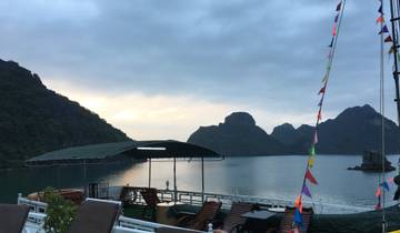 Cruise ship with bunting and scenic view of karsts.
