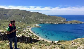 Man enjoying a viewpoint overlooking a beautiful bay and hills.