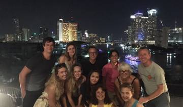 Group photo at night with a city skyline in the background.