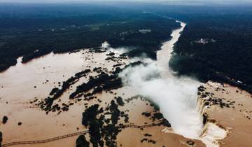 Aerial view of a river with waterfalls and surrounding forest.