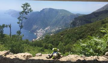 Scenic view of a hilly coastline with a small stuffed toy on a ledge.