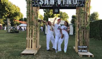 Three women posing at an outdoor entrance.