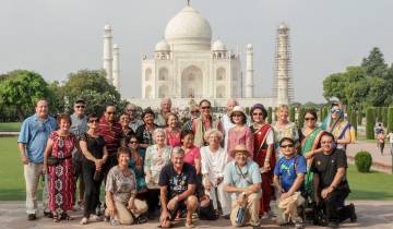 Large group posing in front of the Taj Mahal.
