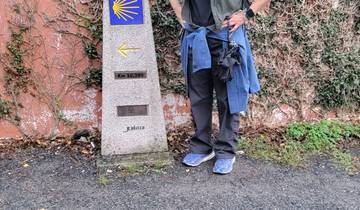 Person with a Camino de Santiago marker and scallop shell symbol.