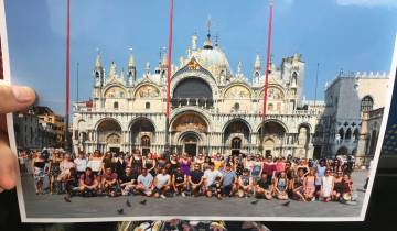 Large group photo in front of a historic basilica.