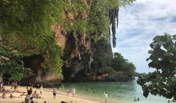 People enjoying a beach with limestone cliffs.