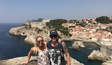 Two people posing with the old town of Dubrovnik in the background.