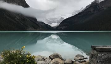 Reflection on a still lake surrounded by majestic mountains.