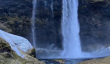 A stunning waterfall with surrounding cliffs.