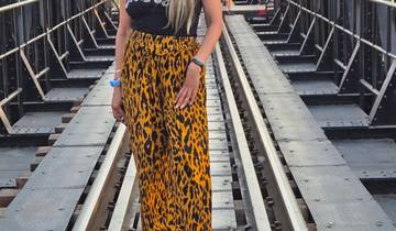 A woman standing on a bridge over a river.