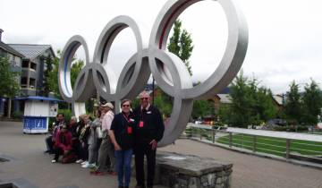 Couple posing in front of the Olympic rings sculpture.