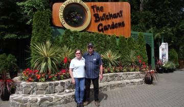Couple posing in front of the Butchart Gardens entrance.