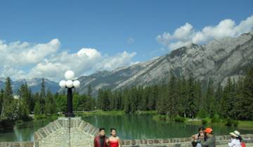 People enjoying scenic view with mountains and a river.