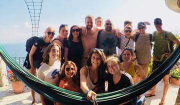 Group of people posing with a hammock in a tropical setting.