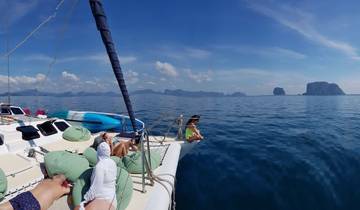People relaxing on a boat with scenic islands in the background.