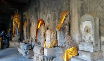 Stone statues in a temple with colorful fabric draped.