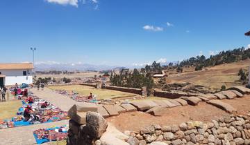 Market area with textile goods and large mountains in the background.