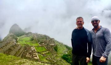 Two men posing with Machu Picchu in the background.