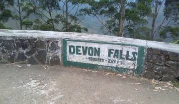 Sign indicating Devon Falls with a scenic background.
