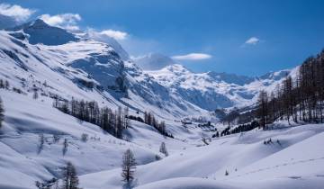 Snow-covered mountains under a blue sky.