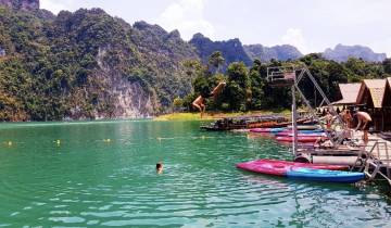 People swimming and diving in a picturesque lake.