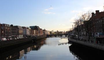 View of a river with historic buildings lining the banks.