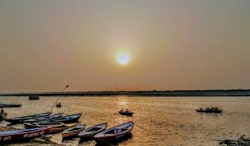 Boats on a river at sunset with a scenic view.