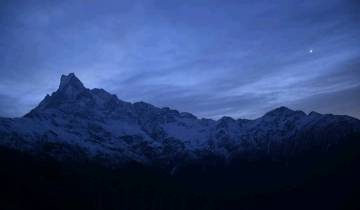 Mountain silhouette against a starry twilight sky.