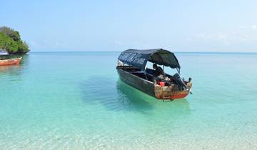 Traditional boat sailing on clear turquoise water.