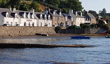 Seaside village with stone houses and boats.