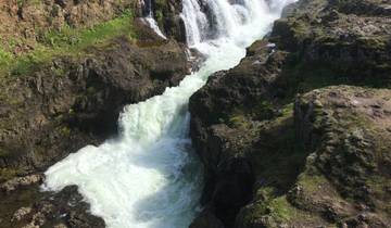 Waterfall cascading down rocky terrain.