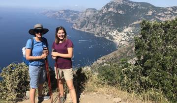 Two women hiking with a view of the Amalfi Coast.